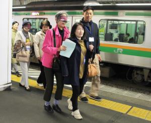 駅ホームでアイマスクをして歩行体験