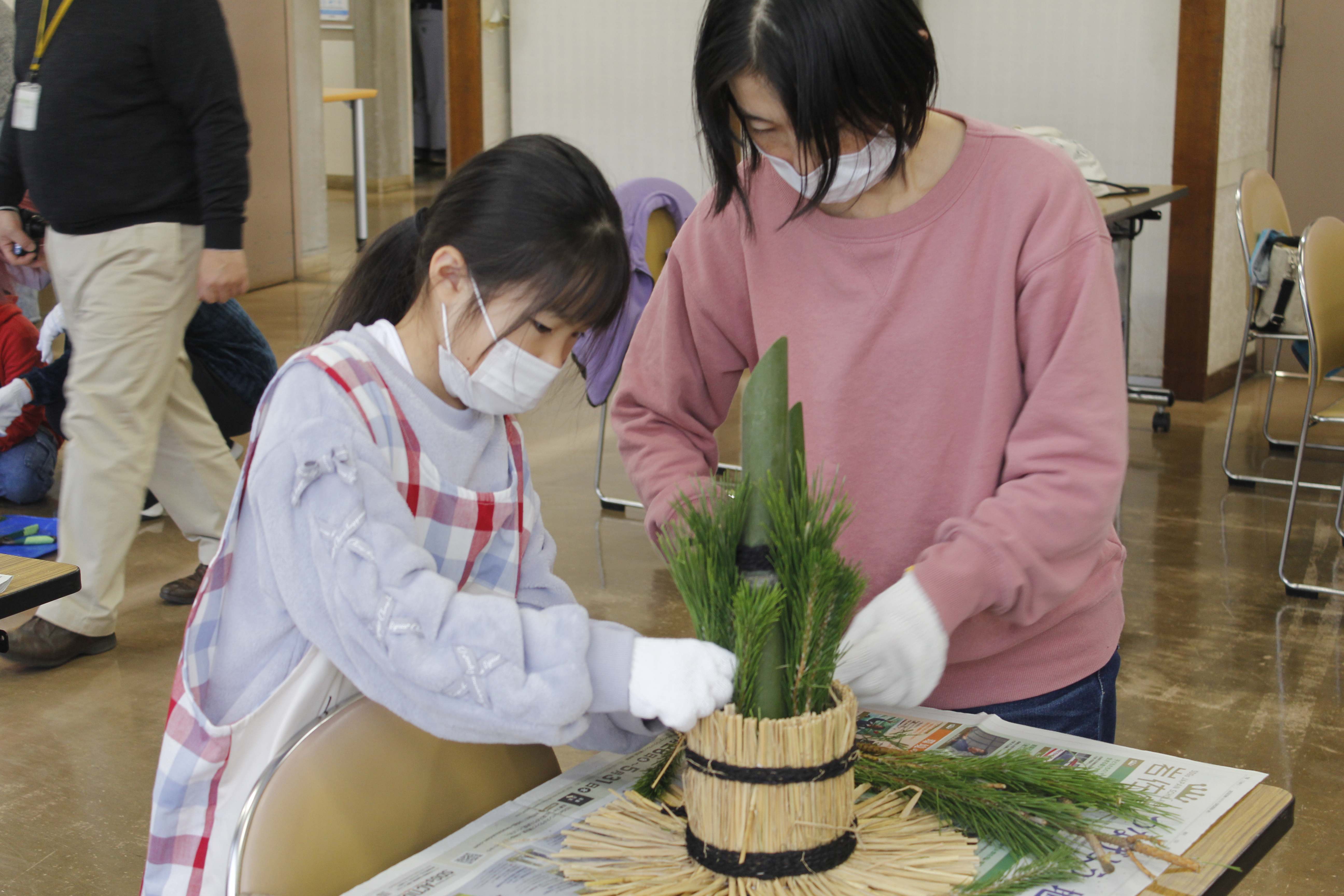 飾り付けのバランスを整える小学生と保護者